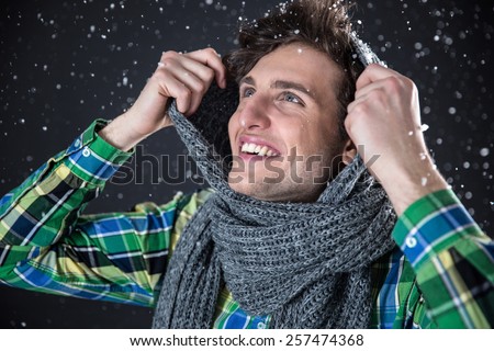 Smiling handsome man with snow on background. Winter coming