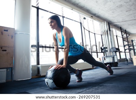 Young woman doing exercise with fit ball at gym