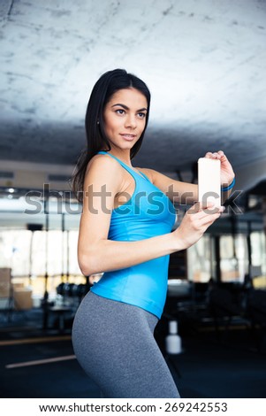 Happy fit woman making selfie photo at gym
