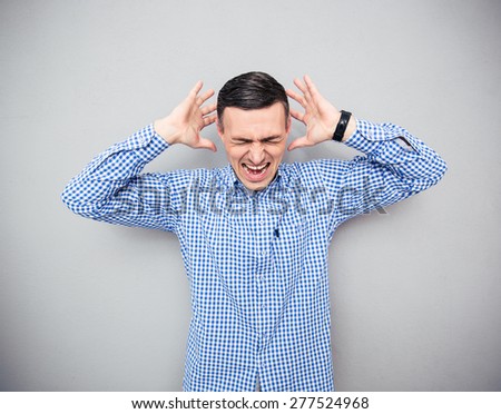 Depressed man screaming over gray background