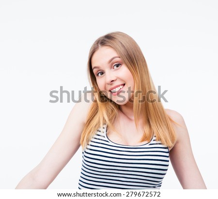 Happy young woman shrugging her shoulders over gray background and looking at camera