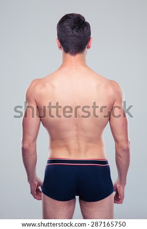 Back view portrait of a muscular man over gray background
