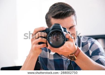 Casual man shooting with photo camera