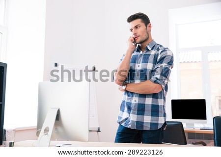 Businessman in casual cloth talking on the phone in office