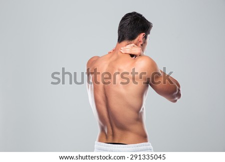 Back view portrait of a man with neck pain over gray background