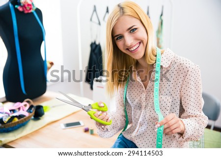 Happy female tailor standing in workshop