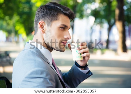 Portrait of a handsome businessman drinking coffee outdoors