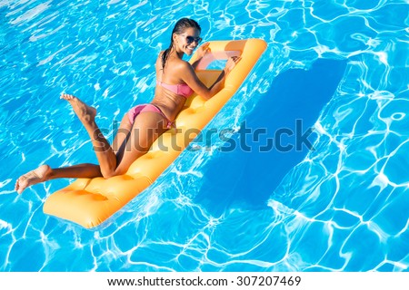 Portrait of attractive woman lying on air mattress in the swimming pool
