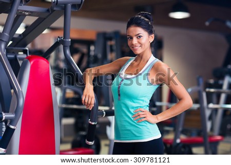 Portrait of a happy beautiful woman standing in fitness gym