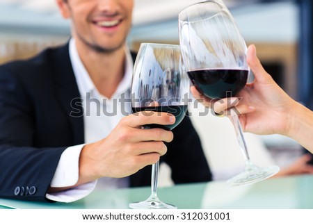 Smiling formal man drinking red wine in restaurant