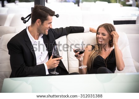 Happy elegant couple drinking red wine in restaurant