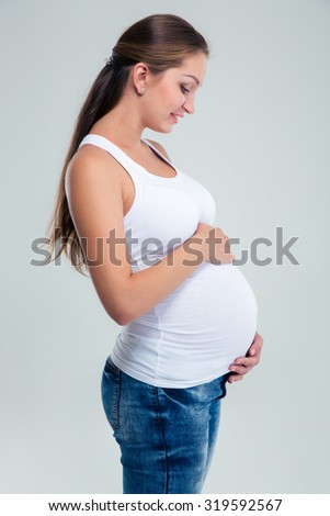 Portrait of a happy pregnant woman caressing her belly isolated on a white background