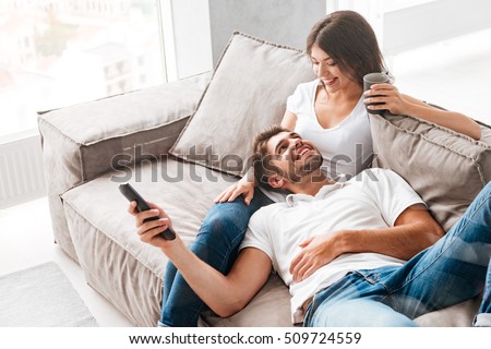 stock photo cheerful beautiful young couple drinking coffee and watching tv at home 509724559 - Ways to Marry a Latina Female