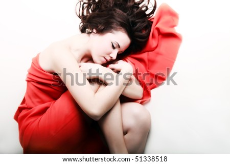 Serene sleeping woman covered with silk red cloth