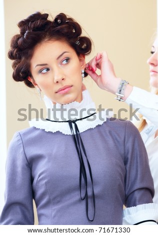 Photo of a young beautiful woman in hair salon. Last improvements on hairstyle.