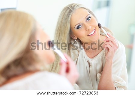 Young beautiful woman smiling to herself in mirror