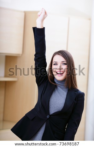 Portrait of happy young woman showing a happy gesture in office