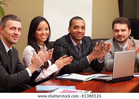 Multi ethnic business group greets you with clapping and smiling. Focus on asian woman