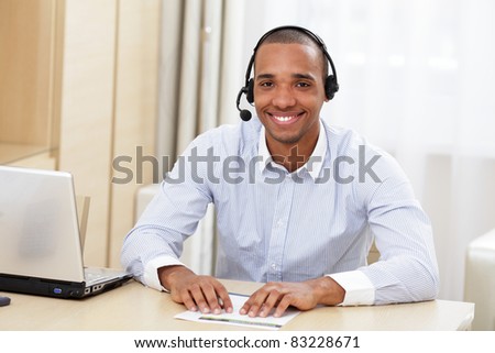 young african call center consultant with headset in office