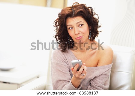 The young beautiful woman sadly waits for a call by phone