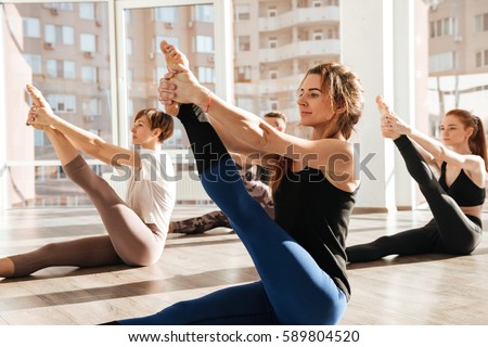 Similar – Image, Stock Photo Slender barefooted woman stretching body in bound angle pose in contemporary studio