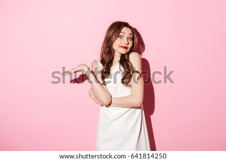 Portrait of a uncertain pretty woman shrugging shoulders isolated over pink background Foto stock © 