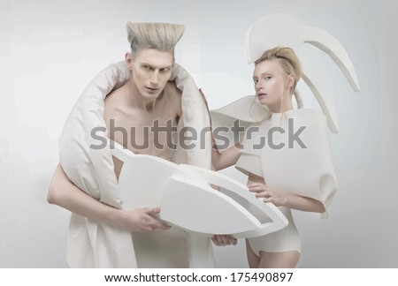 Pale futuristic blonde couple in white outfit over white background