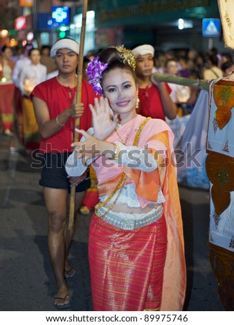 CHIANG MAI, THAILAND - NOVEMBER 9: Young Thai lady dances in colorful costume at the opening parade of the Loy Krathong Festival in Chiang Mai, Thailand on November 9, 2011