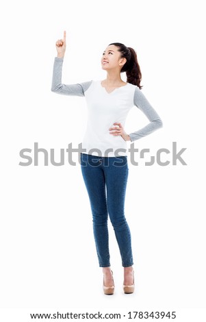 Smiling young woman pointing upwards isolated on white background.