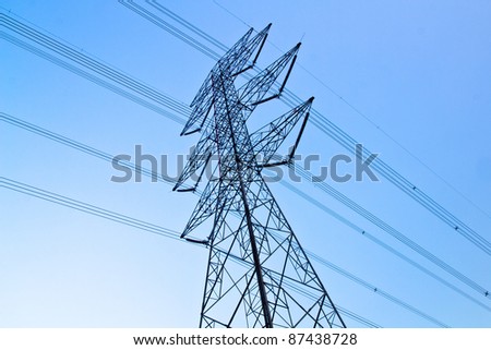 a long line of electrical transmission towers carrying high voltage lines.