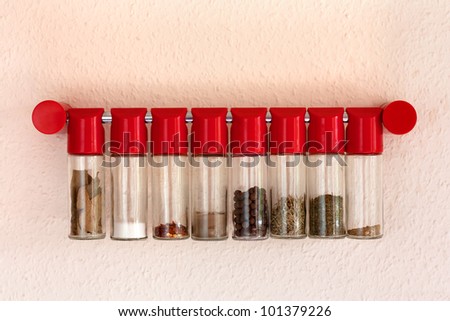 Various spices in bottles hanging on the wall.Bay leaves,salt,red pepper,pepper,savory,curry