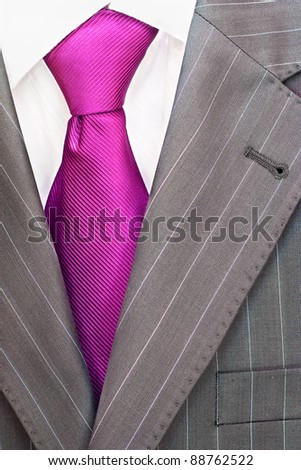 Detail of a men\'s striped business suit.Pink or violet  tie and a shirt