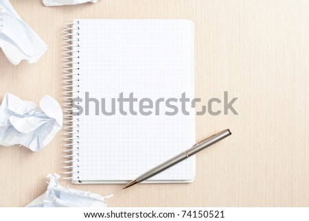 Blank notebook page and crumpled paper wads on desk