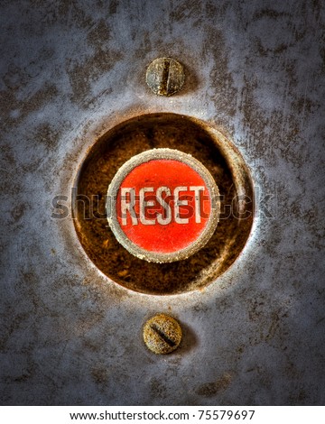 A grunge image of a reset button from the control area for an old elevator lift.