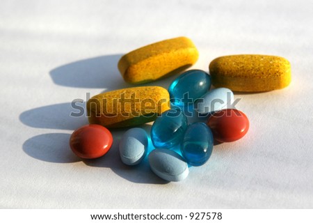 yellow, red, blue and light blue pills arranged on a white background