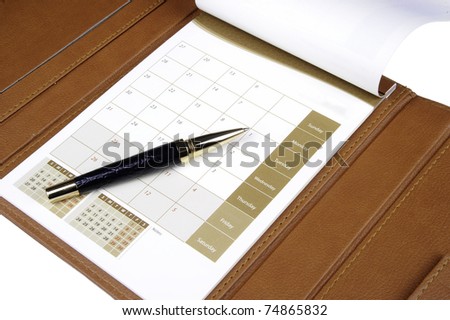 Pen laying on a calendar reading to make entries into the dates for appointments and future commitments
