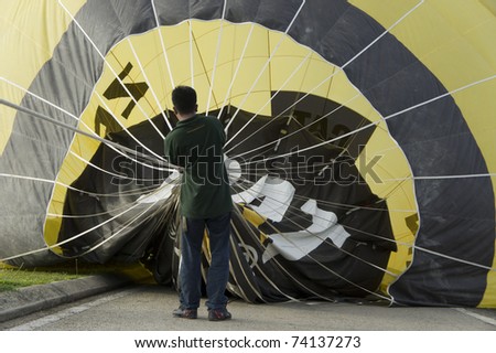 PUTRAJAYA, MALAYSIA-MAR 19:Crew members help preparing a balloon at the 3rd Putrajaya International Hot Air Balloon Fiesta on Mar 19, 2011 in Putrajaya.More than 300,000 people visit this year event