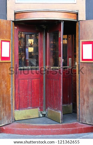 Red revolving door at old pub entrance