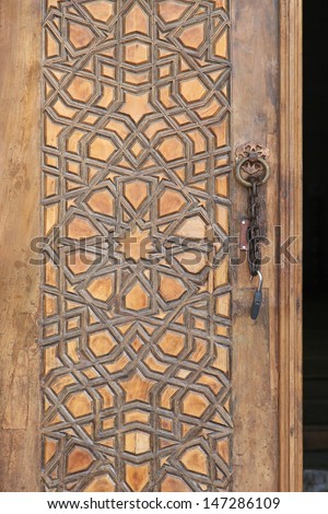 Islamic pattern engraved in wooden door at mosque