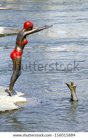 SKOPJE, MACEDONIA - SEPTEMBER 17: Swimmer statue in Skopje on SEPTEMBER 17, 2012. Bronze statue of swimmer woman in bikini at Vardar River in Skopje, Macedonia.