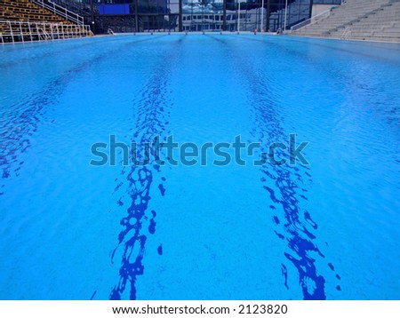 Trembling surface of an Olympic size swimming pool in empty sport arena