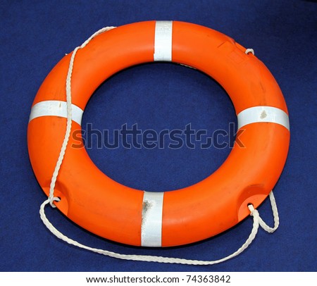 Florescent orange life buoy lifesaver at sea