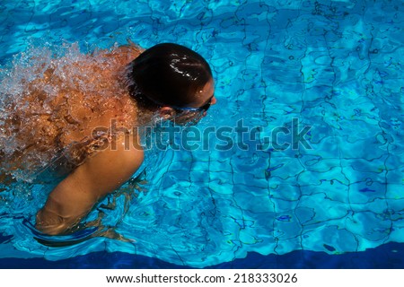 Professional swimmer dives under water in the pool - Stock Image