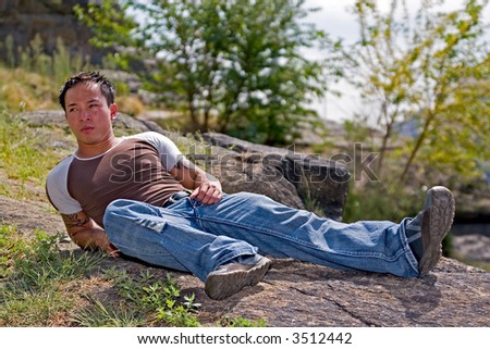 A young asian man relaxing at the park