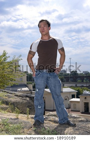 handsome muscular asian man standing on hill
