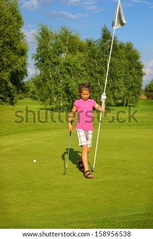 Golf, girl golfer with a stick and a flag on the green