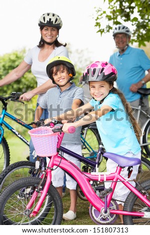 Grandparents And Grandchildren On Cycle Ride In Countryside