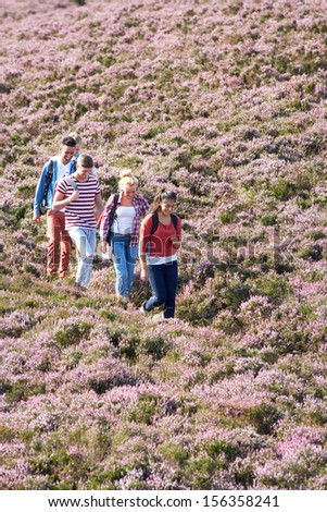 Group Of Young People Hiking Through Countryside
