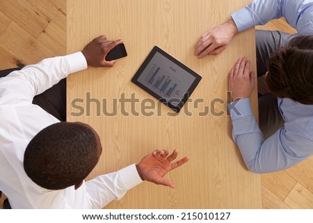 Overhead View Of Businesspeople With Digital Tablet At Desk