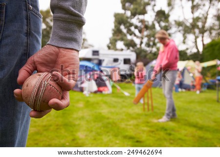 Family Playing Cricket Match On Camping Holiday